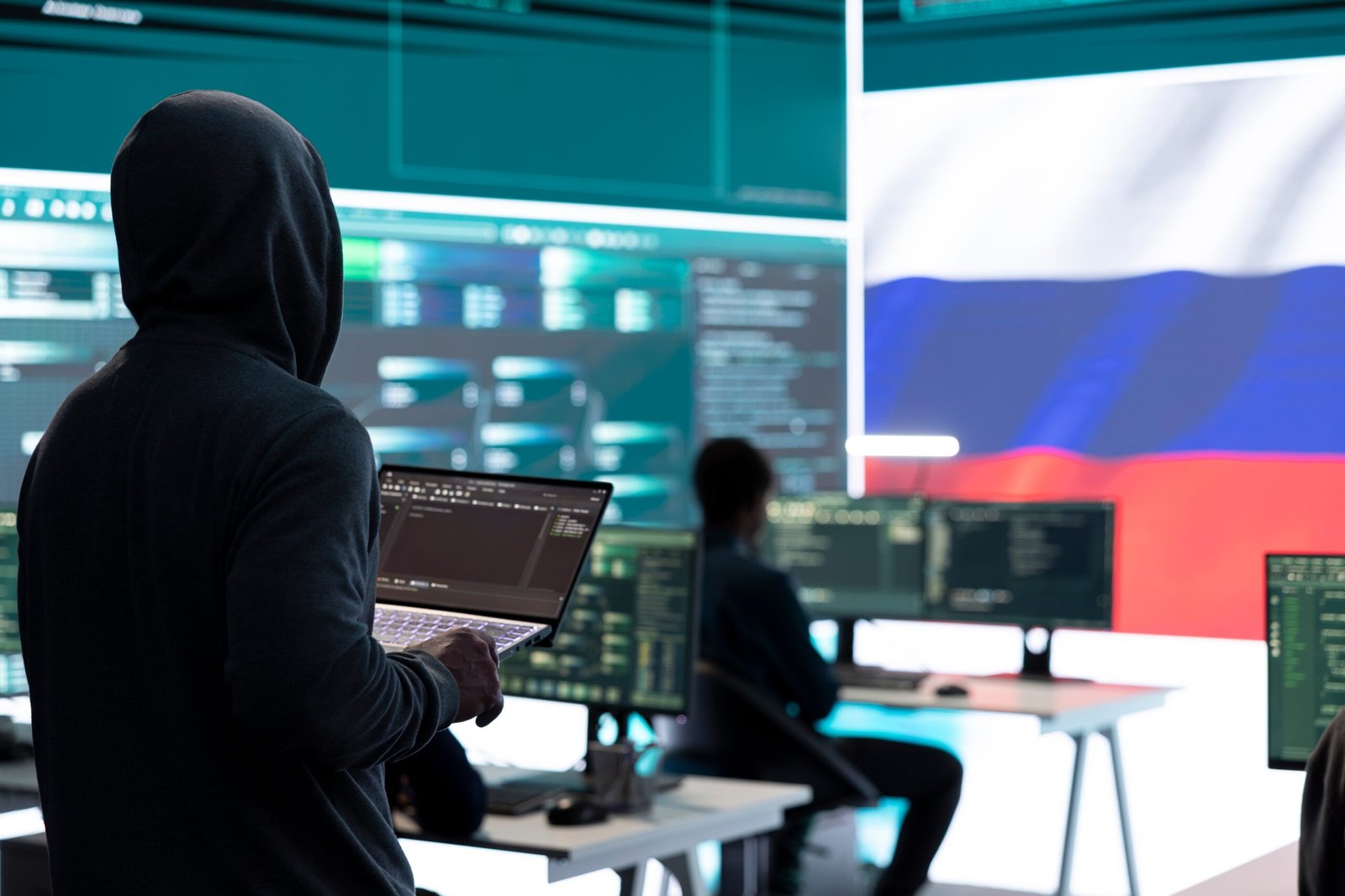 Dishonest person in a Russian cyber security room hacking systems, spreading misinformation and fake news. Russian hackers group on hybrid war tactics and international conflict.