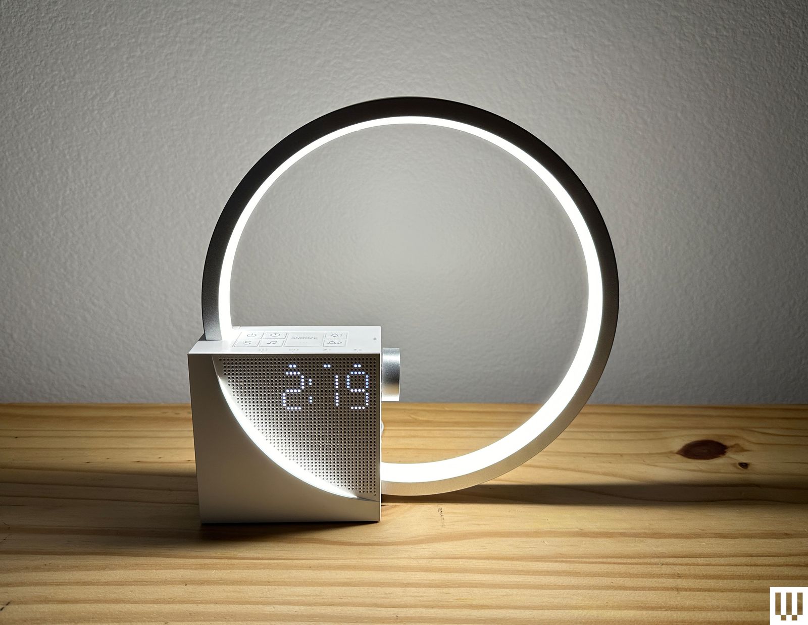Vivilumens Sunrise Alarm Clock a silver ring with a square base attached to the lower left corner