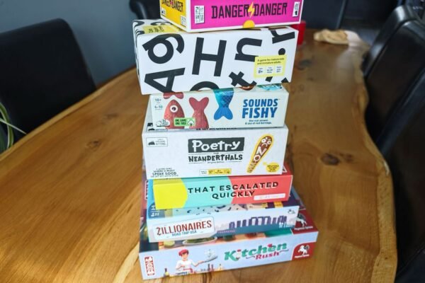 Stack of board game boxes on large wooden table
