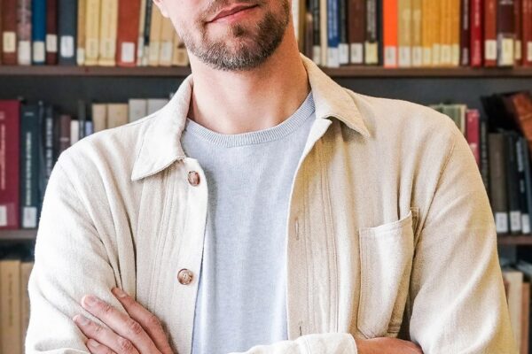 Image may contain Book Indoors Library Publication Adult Person Furniture Bookcase Face and Head